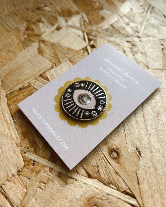 Pin on a card with 'innocentbones.com' on a wooden surface