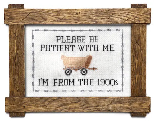 Cross-stitched design with a wooden frame, featuring text and a vintage-style cart.