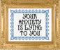 Decorative cross-stitch with 'Your anxiety is lying to you' text in a gold frame.