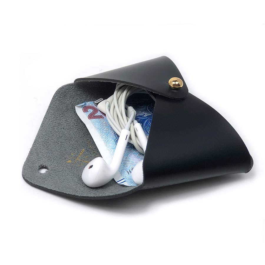 A black leather earbud pouch shown open on a white background, containing white earbuds and a blue banknote.